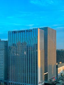 呼和浩特呼和浩特中心皇冠假日酒店的一座大建筑,上面有标志