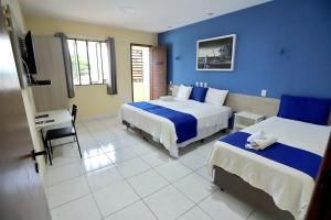 若昂佩索阿Pousada Costera的酒店客房设有两张床和电视。