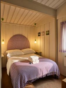 门蒂斯港洛肯德小木屋假日公园的一间卧室配有一张床,上面有两条毛巾