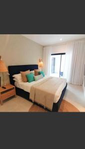 Poste LafayetteEastern Blue Beachfront Luxury Apartment的卧室配有带枕头的大床和窗户。