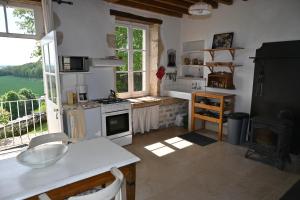 ChampallementMaison Machecourt的一间厨房,配有白色家电和大窗户