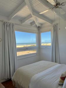 拉佩德雷拉ALMAR- Punta Rubia, La Pedrera的一间卧室设有一张床和两个大窗户