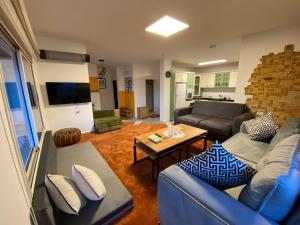 迈季代勒舍姆斯Star Suite - Rural experience - Northeast point的客厅配有蓝色的沙发和桌子