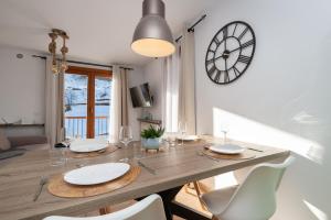 兰索尔APARTAMENTO RANSOL的餐桌、椅子和墙上的时钟