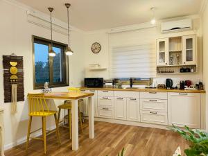 Tirat YehudaOrlinka的厨房配有白色橱柜和木桌