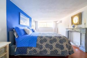 马萨鲁布朗斯Villa Lorelei的蓝色卧室设有一张床和一个壁炉