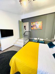 特雷维索Palazzina300的一间卧室配有黄色的床和一台平面电视