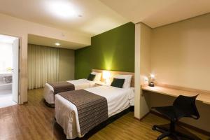 坎皮纳斯坎皮纳斯里加别墅酒店的酒店客房配有两张床和一张书桌