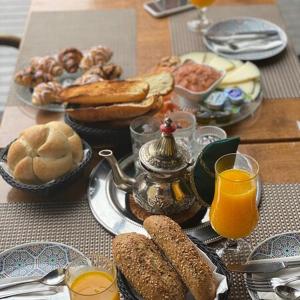 萨拉热窝Teuta Palace Dom Faletići的餐桌,早餐包括面包和橙汁