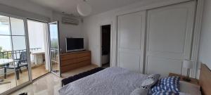 托罗克斯科斯塔Villa D&D的一间卧室设有一张床、一台电视和一个阳台。