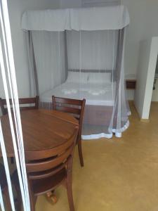 韦利格默Colours of Life Home的卧室配有一张床和一张木桌及椅子