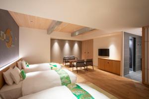 京都Hotel Legasta Kyoto Higashiyama Sanjo的酒店客房设有两张床和一张桌子。
