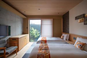 京都Hotel Legasta Kyoto Higashiyama Sanjo的酒店客房设有两张床和大窗户。