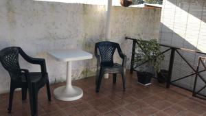 米纳斯Confortable espacio en Minas的阳台配有2把椅子和1张桌子