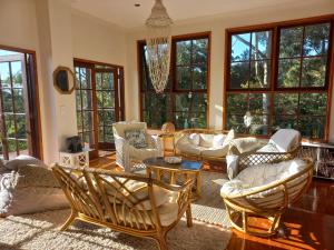 DoonanThe Junglehouse Noosa的带沙发和椅子的客厅以及窗户。