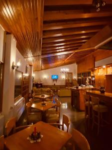 格雷韦纳Milionis Forest Hotel的餐厅设有木制天花板和桌椅