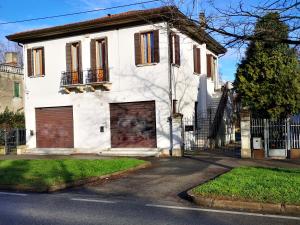 马格拉Noemi Venice Home的白色的房子,在街上有两扇车库门