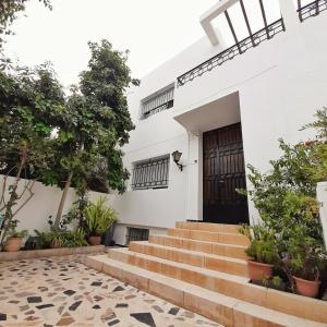 拉巴特Rooms To book in Villa House at HostFamily in Rabat的白色的房子,有楼梯通往门