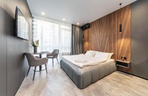 基辅Апартаменти-студіо "Premium Lux Apartments French Quarter 2" з гідромасажною ванною чи з душем的卧室配有一张床和一张桌子及椅子