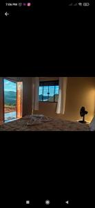 伊比科阿拉Chalé Mirante Das Serras Ibicoara-BA的一间卧室设有一张床和一个美景窗户。