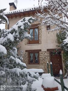 Alameda del ValleEl Refugio de la Sauca的前面的雪覆盖的房子