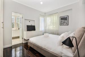悉尼Premium Double Bay 3 bedroom apartment的一间白色卧室,配有床和电视