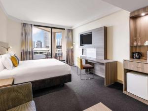 悉尼Sydney Central Hotel Managed by The Ascott Limited的配有一张床和一张书桌的酒店客房
