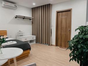 胡志明市B786 Airport Apartment的一间卧室配有床、桌子和植物