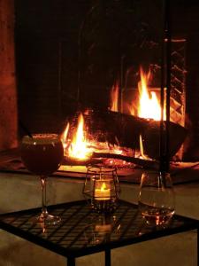 Le Mesnil-ThéribusDomaine l'instant du Colibri的壁炉,桌子上放着两杯和两根蜡烛