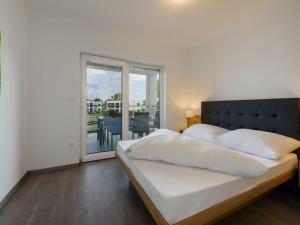 斯拉Elite Holiday Home in Lutzmannsburg with Pool的一间带大床的卧室和一个阳台