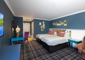 金洛赫兰诺赫Loch Rannoch Hotel and Estate的酒店客房,设有两张床和蓝色的墙壁