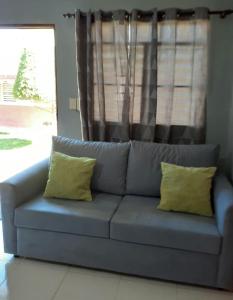 哈拉瓦科阿CASITA HOGAREÑA JARABACOA (independent entrance)的客厅里一张带两个黄色枕头的蓝色沙发