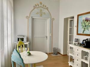 图恩Lovely studio in a villa from 18th century的一间设有白色桌子和镜子的用餐室