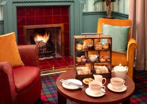 金洛赫兰诺赫Loch Rannoch Hotel and Estate的客厅设有壁炉和带咖啡壶的桌子。