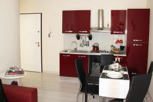 佛罗伦萨圣安特尼诺公寓的厨房配有红色橱柜和桌椅