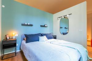 都灵Top Living Apartments - Torino Centro的一间蓝色卧室,配有一张床和镜子