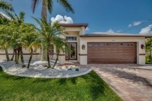 珊瑚角Villa Florida Vacation的一座房子前面有车库和棕榈树