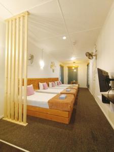 昆达桑Bayu Senja Lodge的客房设有四张床和平面电视。