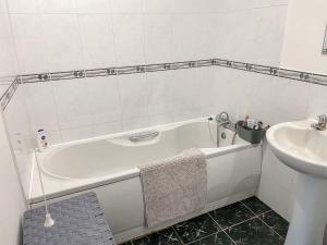 利奇菲尔德4c Gaia Lane的浴室配有白色浴缸和水槽