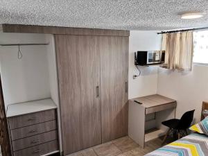 基多Dormitorio Independiente的一间卧室配有一张床、一个橱柜和一张书桌