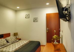 富尔纳斯Vale dos Encantos的一间卧室配有一张床和一台电视。