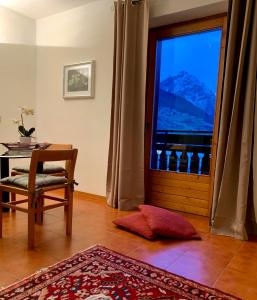 伊索拉察Cima de’ Piazzi Apartment的客房设有桌子和享有美景的窗户。