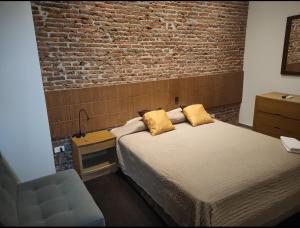 瓜亚基尔HOTEL BOUTIQUE PANAMÁ的一间卧室设有一张床和砖墙