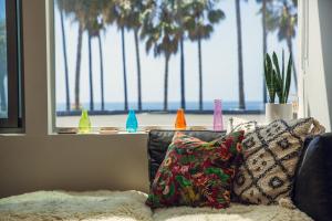 威尼斯STAY OPEN Venice Beach的带沙发的客厅和棕榈树窗户。