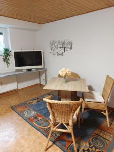 HeddesheimFerienwohnung Juco的客厅配有桌椅和电视。