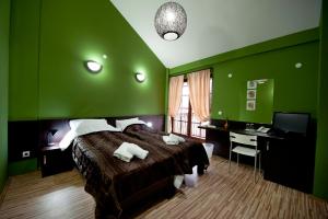 比托拉剧院酒店的绿色卧室配有床和书桌
