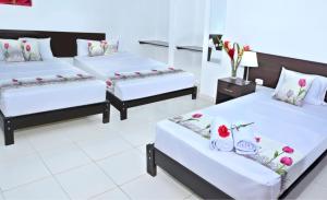 塔拉波托Residencial Lago Verde的两张床位于带鲜花的房间