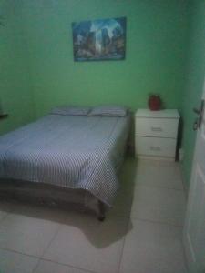 德班Jackies Guest House的一间绿色卧室,配有床和梳妆台