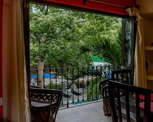 锡瓦塔塔内霍Zihuatanejo studio的一个带椅子的阳台,享有花园的景色