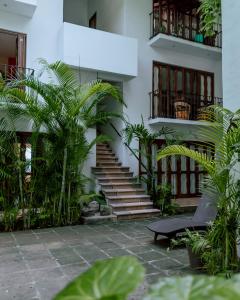 锡瓦塔塔内霍Zihuatanejo studio的庭院中一座带楼梯和植物的建筑